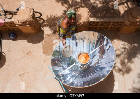 MALI Bandiagara, transition énergétique, la femme à la cuisinière solaire, un miroir parabolique, préparer la nourriture dans le village Banque D'Images