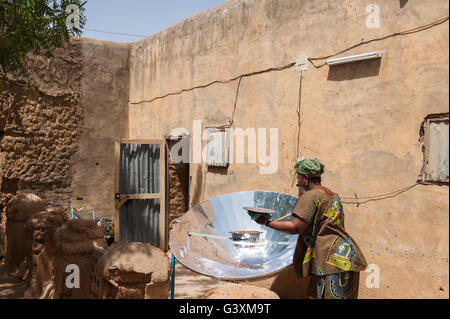 MALI Bandiagara, transition énergétique, la femme à la cuisinière solaire, un miroir parabolique, préparer la nourriture dans le village Banque D'Images