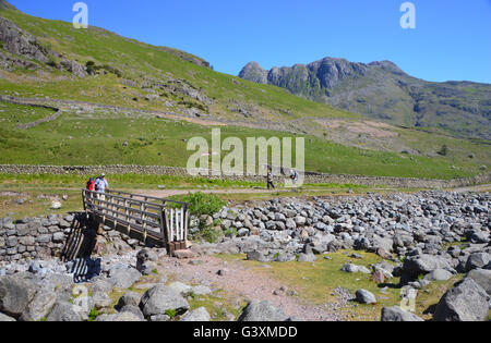 Deux marcheurs Crossing Oxendale Beck sur la passerelle en bois de la vallée de Langdale, Parc National de Lake District, Cumbria, Royaume-Uni Banque D'Images