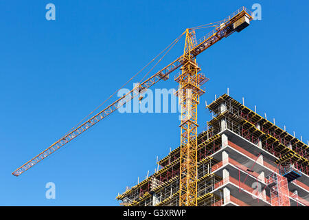 Site de construction contre le ciel bleu avec grue a tour Banque D'Images