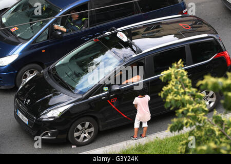 Paris, France. 16 Juin, 2016. Une pose à un taxi dans une rue animée de Saint-Denis près de Paris, France, le 16 juin 2016. Photo : CHRISTIAN CHARISIUS/dpa/Alamy Live News Banque D'Images