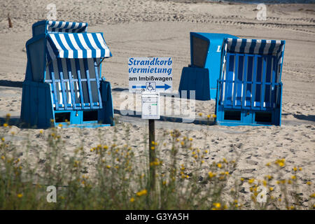 Chaises de plage en osier couvert, un signe "lettrage" trandkorbvermietung allemand, location de chaise de plage", sur la plage de Kühlungsborn Banque D'Images