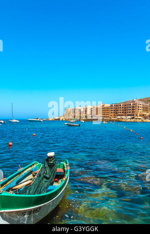 Bateau de pêche amarré dans la baie de Marsalforn et panorama de la plus populaire et la plus grande station d'été de Gozo - Marsalforn, Gozo, Malte Banque D'Images