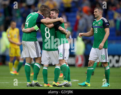 Steven Davis de l'Irlande du Nord (deuxième à gauche), Gareth McAuley (à gauche), Oliver Norwood (deuxième à droite) et Aaron Hughes célèbrent après le coup de sifflet final au cours de l'UEFA Euro 2016, Groupe C match au Parc Olympique Lyonnais, Lyon. Banque D'Images