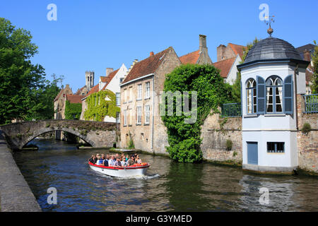 Avec un bateau de croisière touristique le long du canal Groenerei (vert) datant de 1127 à Bruges, Belgique Banque D'Images