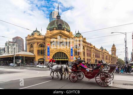 Une calèche traverse en face de la gare de Flinders Street, ville de Melbourne, Australie Banque D'Images