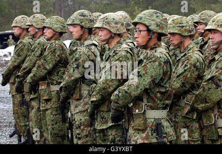 Les soldats de l'auto-défense au sol au Japon effectuer une salve de fusil. Banque D'Images