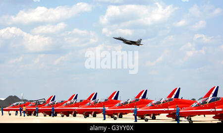 Un F-15 Eagle vole au-dessus de l'équipe de voltige aérienne de la Royal Air Force, les flèches rouges. Banque D'Images