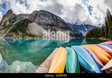 Une vue sur le lac Moraine fisheye dans les Rocheuses canadiennes, avec des canoës de couleur sur l'avant-plan et la vallée des Dix Banque D'Images