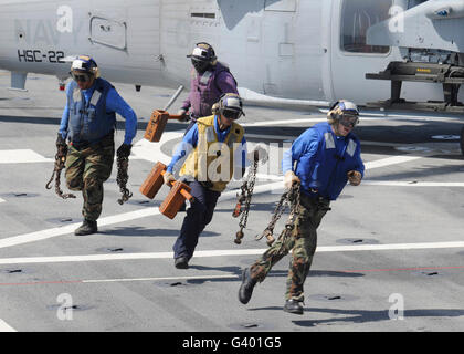 Enlever les cales des marins et les chaînes d'un MH-60S Sea Hawk. Banque D'Images