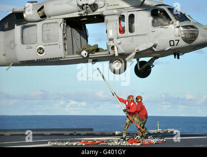 Ordnancemen Aviation un crochet de l'élingue de palette sur un MH-60S Sea Hawk. Banque D'Images