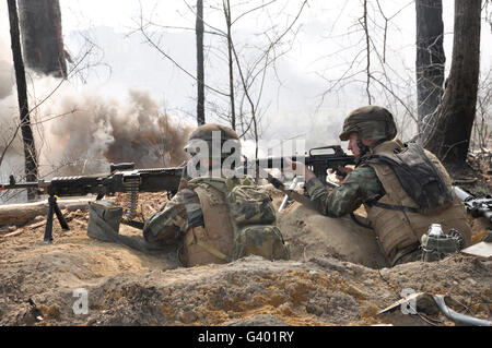 Le feu des soldats de leurs armes d'un trou du renard sur la ligne défensive. Banque D'Images