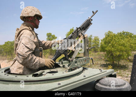 Un Marine s'apprête à congédier son M240 machine gun en montant dans un véhicule de la tourelle. Banque D'Images