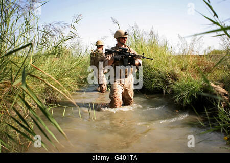 Des soldats patrouillent à travers un canal d'irrigation en Afghanistan Banque D'Images