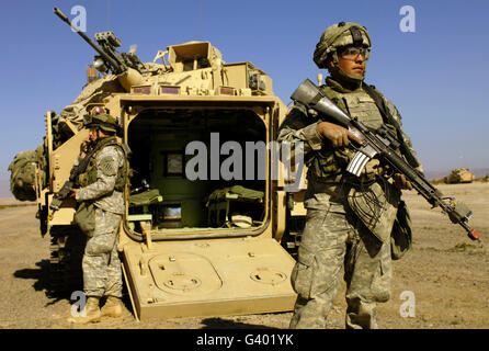 Les soldats de l'armée américaine d'assurer la sécurité d'un véhicule de combat Bradley M2. Banque D'Images