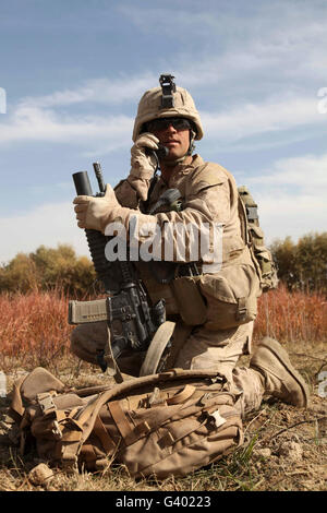 U.S. Marine communique avec ses camarades Marines au moyen d'une radio. Banque D'Images