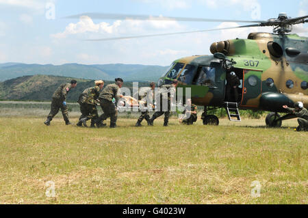 Le personnel médical transporter un patient blessé à un hélicoptère Mi-17. Banque D'Images