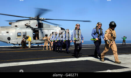 Les marins britanniques sont escorté hors de l'hélicoptère EH-101 Merlin à bord du USS John C. Stennis. Banque D'Images