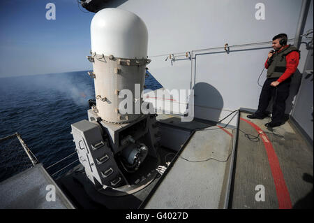 Controlman feu regarde un gros système d'armes à feu à bord du USS John C. Stennis. Banque D'Images