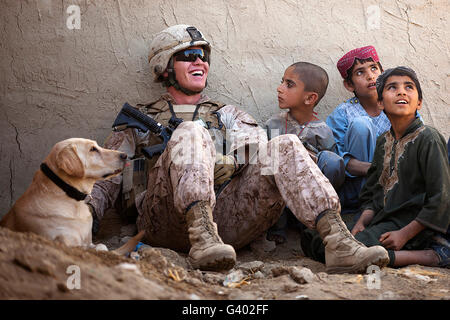 Blagues maritime des États-Unis avec des enfants afghans à l'extérieur d'une résidence locale. Banque D'Images