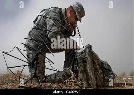 Un soldat communique à l'aide d'un système de communication par satellite. Banque D'Images