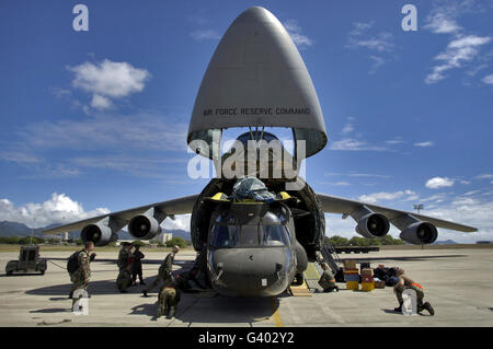 Aviateurs et soldats charger un hélicoptère CH-47 Chinook sur un C-5 Galaxy. Banque D'Images