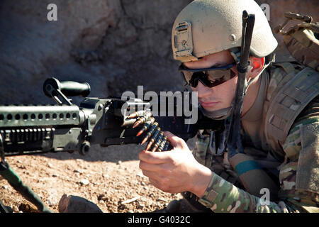 Un membre de la force de la coalition maintient la sécurité dans un village afghan. Banque D'Images