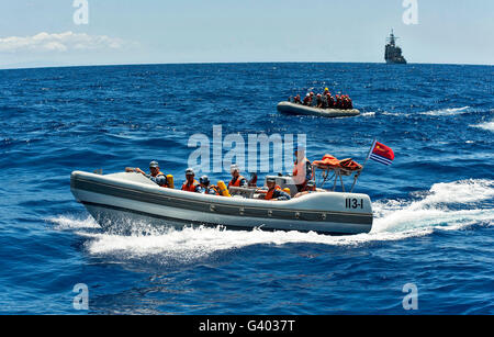 Des marins de crêtes sur la coque des bateaux gonflables lors d'une recherche d'un exercice de sauvetage. Banque D'Images