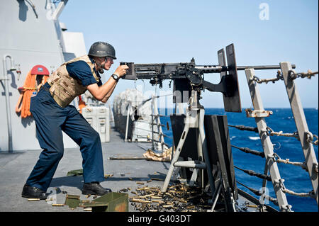 Gunnerâ€™accouplent Seaman tire une mitrailleuse de calibre .50. Banque D'Images