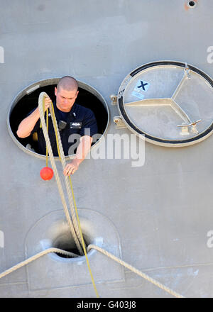 Un marin à bord des lignes poignées littoral lutte contre le USS Indépendance. Banque D'Images