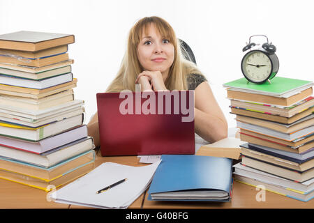 Étudiant échevelé assis à la table et à la recherche à l'image Banque D'Images