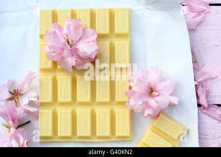 Une barre de chocolat blanc avec des fleurs fleur de cerisier japonais Banque D'Images