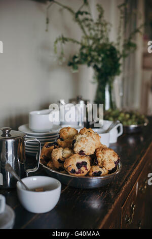 Des petits muffins aux bleuets dans un bol sur un caisson en bois rustique Banque D'Images