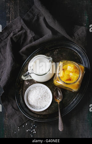 Ingrédients pour des perles de tapioca au lait dessert avec du lait de coco et mangue. Servi sur plateau vintage iron plus ancienne en bois Banque D'Images