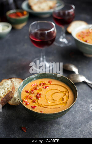 Pesto aux tomates séchées Soupe aux haricots blancs surmontées de tomates séchées et l'huile de chili dans un bol en céramique avec Crostini d'Asiago et rouge Banque D'Images