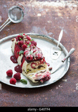 Semifreddo fromage italien ou entremets glacé aux pistaches, framboises et menthe sur vintage silver tray sur rusty gru Banque D'Images