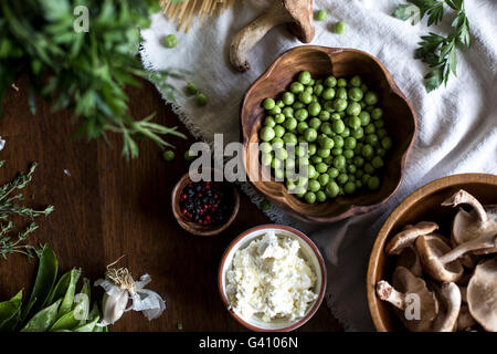 Les ingrédients pour les pâtes avec sauce crémeuse aux champignons et petits pois frais Ricotta - thym, persil, petits pois frais, les champignons shiitake ricotta,c Banque D'Images