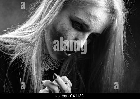 Triste pensive girl avec enduit de produits cosmétiques sur la peau boutonneux sur fond noir, monochrome Banque D'Images