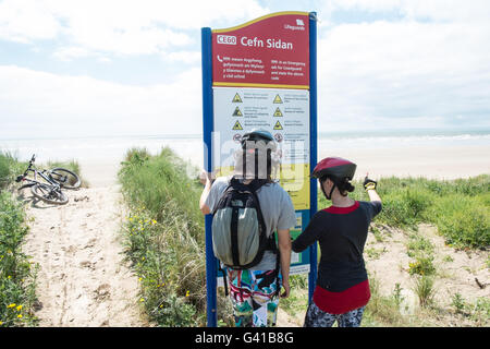 Randonnée à vélo le long d'une partie de 8kms de long vide Pembrey Sands Beach sur un dimanche ensoleillé de juin. Carmarthenshire, Pays de Galles Banque D'Images