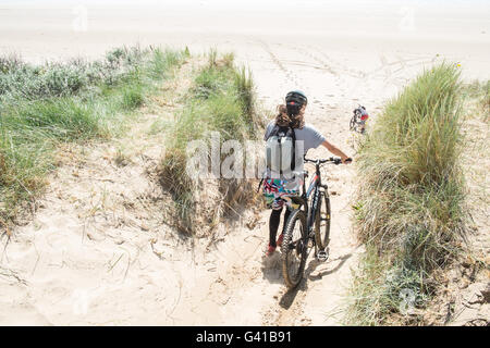 Randonnée à vélo le long d'une partie de 8kms de long vide Pembrey Sands Beach sur un dimanche ensoleillé de juin. Carmarthenshire, Pays de Galles Banque D'Images