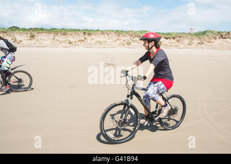 Randonnée à vélo le long d'une partie de 8kms de long vide Pembrey Sands Beach sur un dimanche ensoleillé de juin. Carmarthenshire, Pays de Galles Banque D'Images