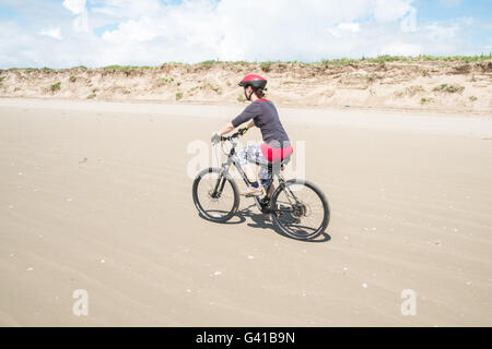 Randonnée à vélo le long d'une partie de 8kms de long vide Pembrey Sands Beach sur un dimanche ensoleillé de juin. Carmarthenshire, Pays de Galles Banque D'Images