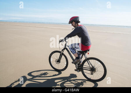 Randonnée à vélo le long d'une partie de 8kms de long vide Pembrey Sands Beach sur un dimanche ensoleillé de juin. Carmarthenshire, Pays de Galles Banque D'Images