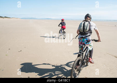 Mère,et,fils,famille,sur,montagne,vélos,Cyclisme le long d'une partie de la plage vide de 8 km de long Pembrey Sands sur un dimanche ensoleillé en juin. Carmarthenshire, pays de Galles Banque D'Images