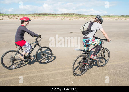 Mère,et,fils,famille,sur,montagne,vélos,Cyclisme le long d'une partie de la plage vide de 8 km de long Pembrey Sands sur un dimanche ensoleillé en juin. Carmarthenshire, pays de Galles Banque D'Images