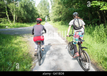 Famille,Cyclisme sur le réseau national de Cyclisme route 4,Londres à Fishguard.Here sur le chemin à travers la forêt de pins à Pembrey Country Park,pays de Galles,gallois,côte, Banque D'Images