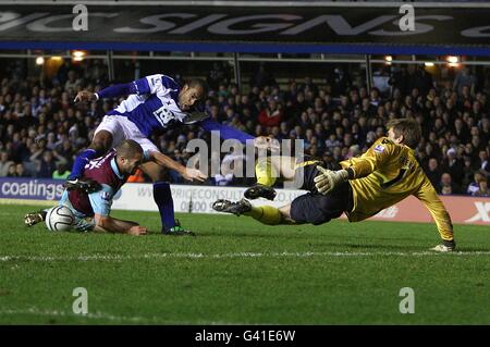 Cameron Jerome (au centre) de Birmingham City et Matthew de West Ham United Udson s'emmêle dans la boîte de West Ham United en tant que gardien de but Robert Green les ferme Banque D'Images