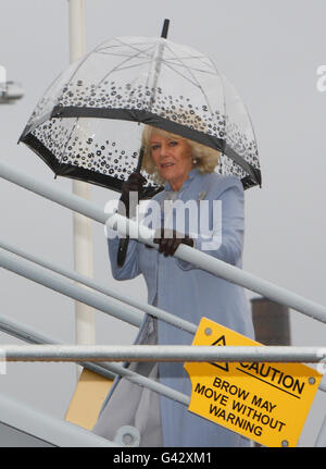 La Duchesse de Cornwall abrite sous un parapluie alors qu'elle négocie le gangway après son arrivée pour une visite à bord du navire auxiliaire de la flotte royale, RFA Argus, pour voir les installations et rencontrer le personnel du navire-hôpital, à la base navale royale de Portsmouth. Banque D'Images