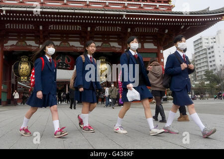 Ecolières marche dans Tokyo avec masque anti-pollution, le Japon © Fabio Mazzarella/Sintesi/Alamy Stock Photo Banque D'Images