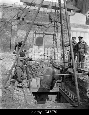 Des hommes de l'unité d'élimination de la bombe n° 2 transportent une bombe allemande de 2,500 hors du sol sous un bâtiment partiellement démoli au large de Tottenham court Road. Banque D'Images